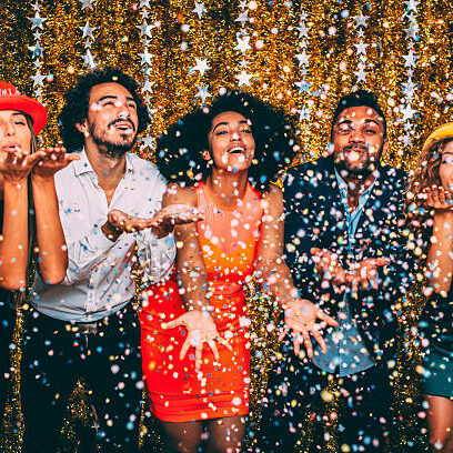 Friends blowing confetti at a new years in vegas party.